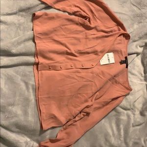An elbow sleeved peach shirt.